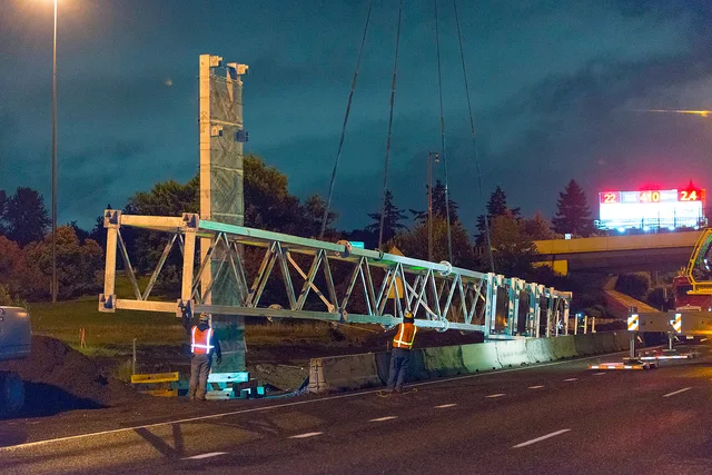 Crews install the sign bridge for RealTime signs going in on I-205 in the Portland Metro area. How OSHA and state contractor boards govern sign installer hiring in the U.S