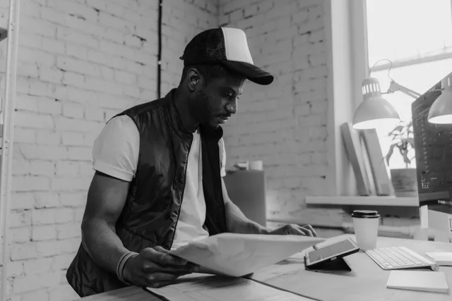 A professional man reviewing business papers at a desk, illustrating work environment and concentration. What Sign Shop Software Should Track