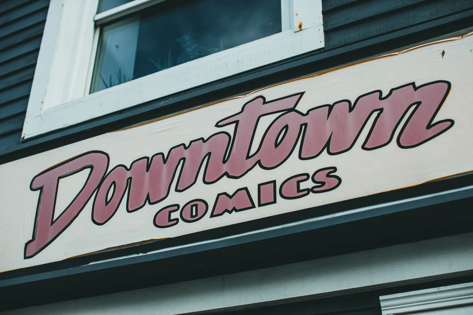 Close-up of a retro 'Downtown Comics' sign on a building facade. What is actually driving demand shifts in the sign shop market?