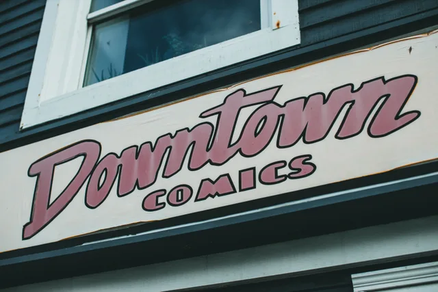 Close-up of a retro 'Downtown Comics' sign on a building facade. What is actually driving demand shifts in the sign shop market?